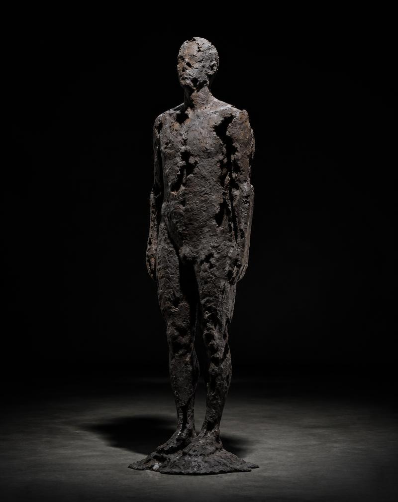A cast bronze sculpture with organic, eroded edges